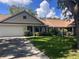 Charming home featuring a lush green lawn, mature trees, and an attached two-car garage at 8450 Sw 90Th St # D, Ocala, FL 34481