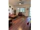 Spacious living room with hardwood floors, natural light from bay window, and a ceiling fan at 8450 Sw 90Th St # D, Ocala, FL 34481