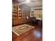 A spacious office with custom built-in shelving, desk, hardwood floors, and a patterned Persian rug at 8450 Sw 90Th St # D, Ocala, FL 34481