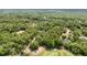 An aerial view showcases this charming property nestled within a lush, green forest landscape at 8605 Sw 209Th Court Rd, Dunnellon, FL 34431