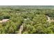 Aerial view of a home surrounded by trees with a long, winding dirt driveway at 8605 Sw 209Th Court Rd, Dunnellon, FL 34431