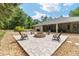 Stone backyard fire pit area that features seating and access to home's screened patio at 8605 Sw 209Th Court Rd, Dunnellon, FL 34431
