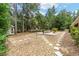 Picturesque backyard featuring a stone fire pit with seating amid lush greenery and stepping stone pathway at 8605 Sw 209Th Court Rd, Dunnellon, FL 34431