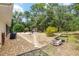 Beautiful backyard featuring a fire pit area, landscaping, and lush trees at 8605 Sw 209Th Court Rd, Dunnellon, FL 34431