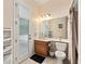 Bathroom featuring wood vanity, toilet, decorative mirror, tile flooring, and exterior door at 8605 Sw 209Th Court Rd, Dunnellon, FL 34431