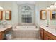 Bathroom featuring a soaking tub, double vanity, and neutral color scheme at 8605 Sw 209Th Court Rd, Dunnellon, FL 34431