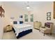 Bright bedroom features two large windows, bedside tables, and an upholstered chair at 8605 Sw 209Th Court Rd, Dunnellon, FL 34431