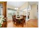 Formal dining room features wood floors, elegant chandelier, and large windows at 8605 Sw 209Th Court Rd, Dunnellon, FL 34431