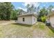 View of the rear exterior showcasing well-kept lawn and neutral stucco at 8605 Sw 209Th Court Rd, Dunnellon, FL 34431