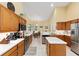 Bright eat-in kitchen featuring stainless steel appliances, wood cabinets, and center island at 8605 Sw 209Th Court Rd, Dunnellon, FL 34431