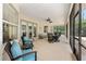 Comfortable screened patio featuring a ceiling fan and access to the outdoors at 8605 Sw 209Th Court Rd, Dunnellon, FL 34431