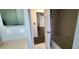 Bathroom boasts a tub and vanity, with modern tile flooring and a doorway view to another room at 8771 Sw 115Th St, Ocala, FL 34481