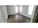 A well-lit bedroom with two large windows, wood-look flooring, and a ceiling fan at 8771 Sw 115Th St, Ocala, FL 34481