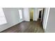 A spacious bedroom featuring wood flooring, white walls, and closet and hallway access at 8771 Sw 115Th St, Ocala, FL 34481