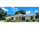 Inviting single-story home with manicured front lawn and beautiful flower beds under a blue sky at 8771 Sw 115Th St, Ocala, FL 34481