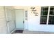 Charming front porch showcasing the home's address and entry with textured wall and window at 8771 Sw 115Th St, Ocala, FL 34481