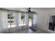 Sunroom with sheer curtains, ceiling fan, and door leading to outdoor area offers peaceful relaxation at 8771 Sw 115Th St, Ocala, FL 34481