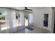 Sunroom featuring large windows with sheer curtains and door to yard, creating a bright and airy space at 8771 Sw 115Th St, Ocala, FL 34481