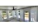 Sunroom with sheer curtains, ceiling fan, and door leading to outdoor area offers peaceful relaxation at 8771 Sw 115Th St, Ocala, FL 34481