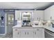 Bright kitchen features white cabinets, stainless appliances, and a view of the backyard at 8841 Sw 91St St # A, Ocala, FL 34481