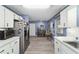 Bright kitchen featuring white cabinetry, stainless steel appliances, and durable wood-look flooring at 8841 Sw 91St St # A, Ocala, FL 34481