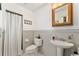 Cozy bathroom with beadboard walls, pedestal sink, and a shower with a white curtain at 9095 Sw 9Th Ter, Ocala, FL 34476