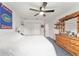 Well-lit bedroom includes ceiling fan, closet, and wood dresser at 9095 Sw 9Th Ter, Ocala, FL 34476