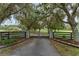 Elegant gated entrance with stone pillars and mature trees, leading to a private estate at 9095 Sw 9Th Ter, Ocala, FL 34476