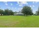 Spacious home with a large, grassy front yard and mature trees on a sunny day at 9095 Sw 9Th Ter, Ocala, FL 34476