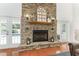 Charming stone fireplace with a wooden mantel, decorative accents, and double doors to the pool at 9095 Sw 9Th Ter, Ocala, FL 34476