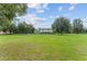 Home with expansive front lawn, mature trees, and a classic fence, showcasing country charm at 9095 Sw 9Th Ter, Ocala, FL 34476