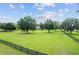 Picturesque property with a long, grassy lawn, mature trees, and classic country fencing at 9095 Sw 9Th Ter, Ocala, FL 34476