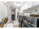 Laundry room with gray washer and dryer, white cabinets, and staircase at 9095 Sw 9Th Ter, Ocala, FL 34476