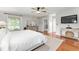 Spacious main bedroom with hardwood floors, a ceiling fan and a tv at 9095 Sw 9Th Ter, Ocala, FL 34476