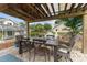 Covered outdoor dining area with elegant table, chairs, and a charming garden view with a bridge at 9095 Sw 9Th Ter, Ocala, FL 34476