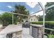 This outdoor kitchen has a grill, sink, mini fridge, and stone accents. It's perfect for entertaining around the pool at 9095 Sw 9Th Ter, Ocala, FL 34476