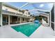 A covered pool with a slide, lounge seating and an entertainment area in the background make this space fun and luxurious at 9095 Sw 9Th Ter, Ocala, FL 34476