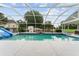 A screened pool with a slide and a basketball hoop for active enjoyment at 9095 Sw 9Th Ter, Ocala, FL 34476