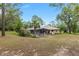 Backyard featuring a screened-in pool and spacious greenery, perfect for outdoor enjoyment at 9180 Sw 202Nd Avenue Rd, Dunnellon, FL 34431