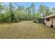 Spacious backyard featuring a home with a screened-in pool, palm tree, and ample green space at 9180 Sw 202Nd Avenue Rd, Dunnellon, FL 34431