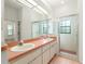 Bright bathroom featuring double sinks, a shower with glass doors, and ample counter space at 9180 Sw 202Nd Avenue Rd, Dunnellon, FL 34431