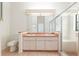 Bathroom with double sinks, vanity, large mirror, toilet, and glass-enclosed shower with seat at 9180 Sw 202Nd Avenue Rd, Dunnellon, FL 34431