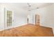 Light-filled bedroom featuring wood floors, white walls, ceiling fan, and access to the bathroom at 9180 Sw 202Nd Avenue Rd, Dunnellon, FL 34431