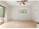 A bright bedroom featuring a ceiling fan, a window with views, and a sliding glass door at 9180 Sw 202Nd Avenue Rd, Dunnellon, FL 34431
