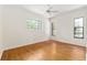Bright bedroom featuring wood floors, a ceiling fan, and well-lit windows with outside views at 9180 Sw 202Nd Avenue Rd, Dunnellon, FL 34431