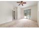 A spacious bedroom with neutral carpeting, ceiling fan, and sliding glass doors to the pool area at 9180 Sw 202Nd Avenue Rd, Dunnellon, FL 34431