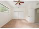 Cozy bedroom featuring a ceiling fan, window, and closet space for ample storage and comfort at 9180 Sw 202Nd Avenue Rd, Dunnellon, FL 34431