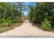 View down the long driveway to the home, surrounded by mature trees and landscaping at 9180 Sw 202Nd Avenue Rd, Dunnellon, FL 34431