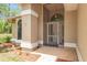 Covered entryway with a stained glass door, brick flooring, and decorative mulch landscaping at 9180 Sw 202Nd Avenue Rd, Dunnellon, FL 34431