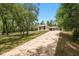 A view of the home's long driveway, surrounded by mature trees and landscaping at 9180 Sw 202Nd Avenue Rd, Dunnellon, FL 34431